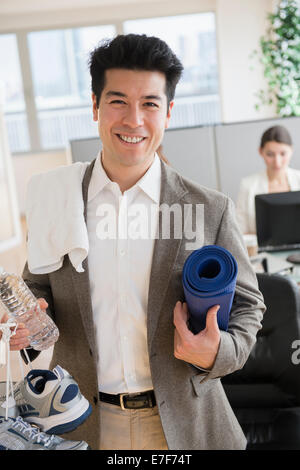 Businessman carrying tenue de sport in office Banque D'Images