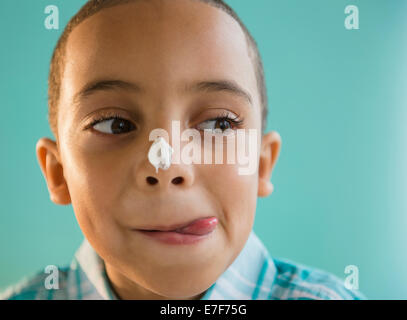 Mixed Race boy avec du glaçage sur le nez Banque D'Images