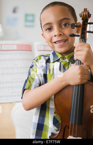 Mixed Race boy holding violin Banque D'Images