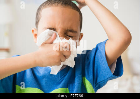 Mixed Race boy blowing son nez Banque D'Images