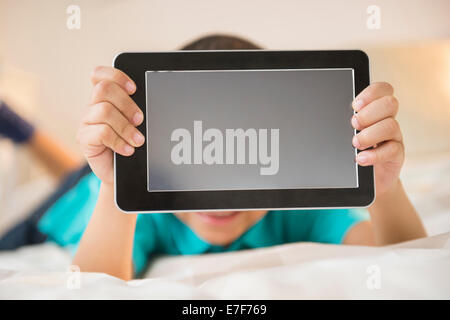 Mixed Race boy holding tablet computer Banque D'Images