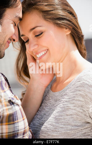 L'homme souriant visage de femme caressant Banque D'Images