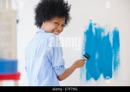 African American Woman painting wall Banque D'Images