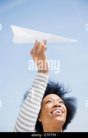 African American Woman throwing paper airplane Banque D'Images