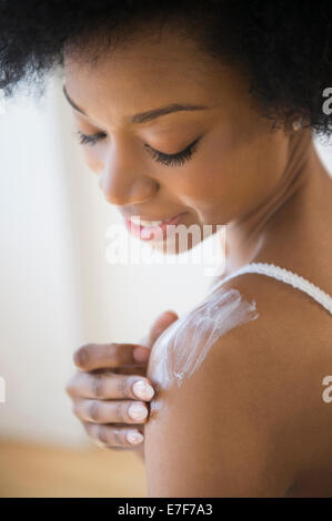 African American Woman applying moisturizer Banque D'Images