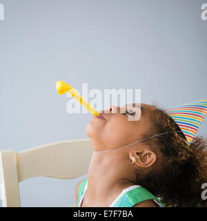 African American girl blowing crécelle at Birthday party Banque D'Images