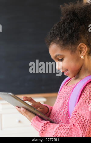 African American girl using tablet computer in classroom Banque D'Images