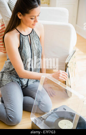Woman listening to vinyl records dans la salle de séjour Banque D'Images