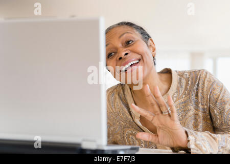 Mixed Race woman using laptop Banque D'Images