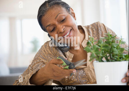 Mixed Race woman usine de fraisage et parlant au téléphone Banque D'Images