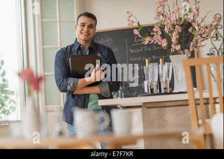 Serveur hispanique smiling in cafe Banque D'Images