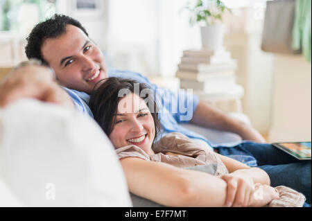 Hispanic couple relaxing together on sofa Banque D'Images