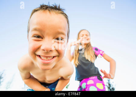 Low angle view of Caucasian children smiling outdoors Banque D'Images