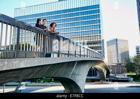 Businesswomen talking on urban pont en ciel Banque D'Images