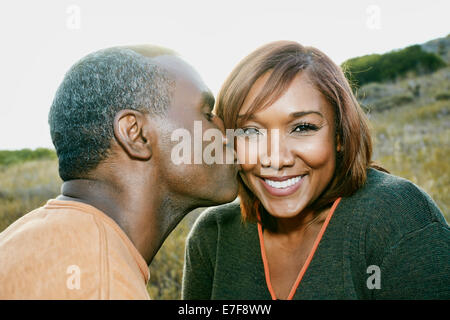 Black man kissing copine on rural hillside Banque D'Images