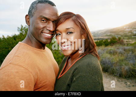 Black couple smiling on rural hillside Banque D'Images