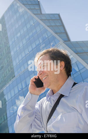 Hispanic businessman talking on cell phone on city street Banque D'Images