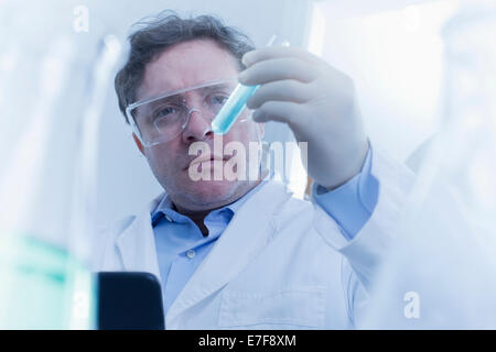 Young Scientist examining test tube in lab Banque D'Images