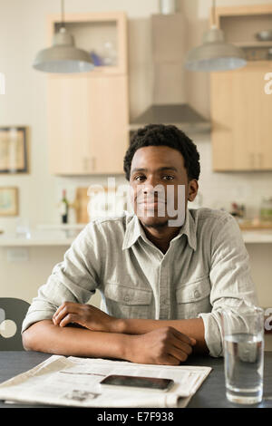 Black Man reading newspaper at breakfast table Banque D'Images