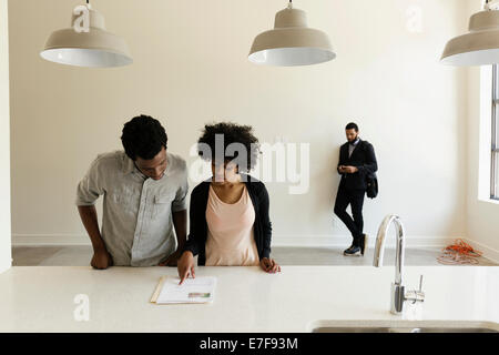 Couple reading paperwork in new house Banque D'Images