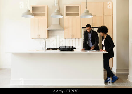 Mixed Race couple reading paperwork in new house Banque D'Images