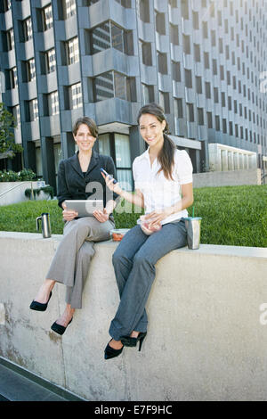 Businesswomen using tablet computer in city Banque D'Images