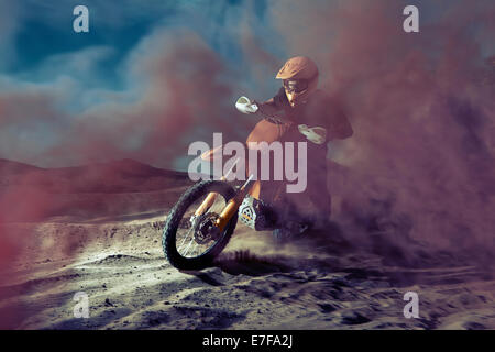 Caucasian man riding dirt bike dans un nuage de poussière Banque D'Images