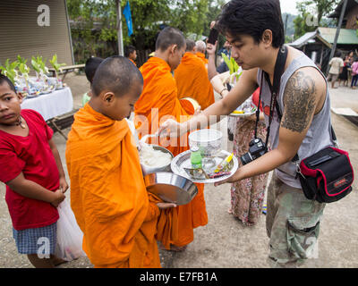 Sangkhla Buri, Kanchanaburi, Thaïlande. 16 Sep, 2014. Les gens présents d'aliments et d'autres offrandes à lun des moines bouddhistes à leurs tours dans la matinée l'aumône à Sangkhla Buri communauté lun. Les LUN sont certaines des premières personnes à s'installer dans le sud-est asiatique, et étaient responsables de la propagation du Bouddhisme Theravada en Thaïlande et en Indochine. La Mon pays est dans le sud-ouest de la Thaïlande et le sud-est du Myanmar (Birmanie). Credit : ZUMA Press, Inc./Alamy Live News Banque D'Images