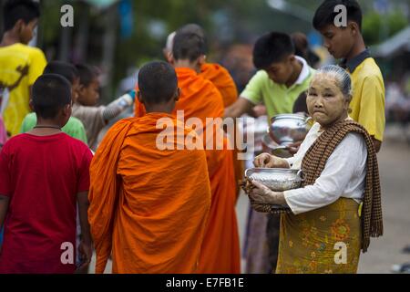 Sangkhla Buri, Kanchanaburi, Thaïlande. 16 Sep, 2014. Une femme s'arrête après avoir présenté mon moines bouddhistes avec des aliments durant la matinée l'aumône ronde de la communauté dans Mon Sangkhla Buri. Les LUN sont certaines des premières personnes à s'installer dans le sud-est asiatique, et étaient responsables de la propagation du Bouddhisme Theravada en Thaïlande et en Indochine. La Mon pays est dans le sud-ouest de la Thaïlande et le sud-est du Myanmar (Birmanie). Credit : ZUMA Press, Inc./Alamy Live News Banque D'Images