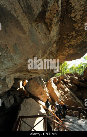 La réserve naturelle du Château des géants, KwaZulu-Natal, Afrique du Sud, grotte principale, les touristes et le guide à la recherche de peintures rupestres Bushmen dans le grès, anthropologie Banque D'Images