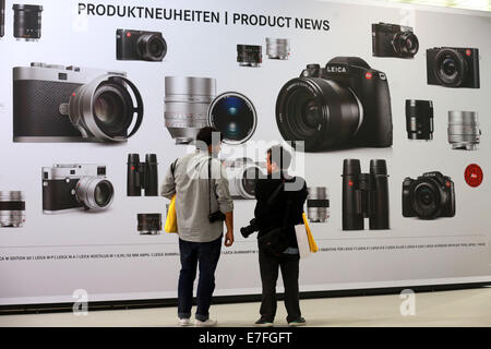 Visiteurs à un affichage des nouveaux appareils photo Leica. Salon de la photographie Photokina à Cologne, Allemagne. Banque D'Images