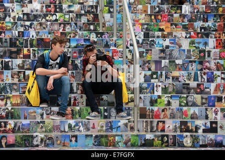 Les visiteurs assis sur un escalier couvert de milliers de photos, Photokina 2014, Cologne, Allemagne Banque D'Images