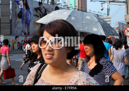 Les femmes à faire leurs achats dans la rue Nanjing, Shanghai. Nanjing Road (chinois : 南京路 ; pinyin : Nánjīng Lù) est la principale rue commerçante de l'al. Banque D'Images