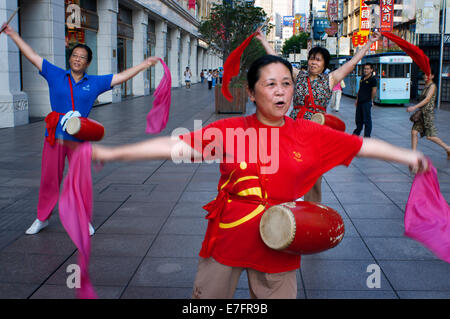 La Chine, Shanghai, Nanjing Road, le tai-chi, d'exercices, les gens avant d'ouvrir les magasins. L'exercice de groupe de tai chi en soirée sur Nanjing Banque D'Images