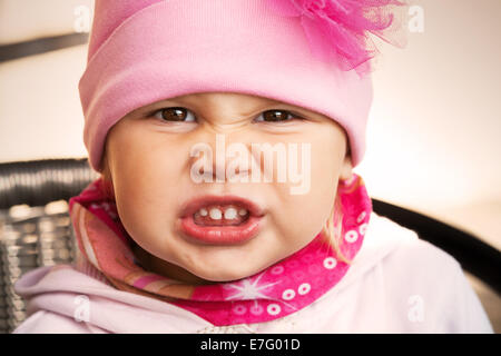 Closeup portrait of funny en colère petite fille en rose Banque D'Images