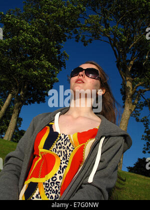 Teenage girl posing in sunshine contre le ciel bleu Banque D'Images