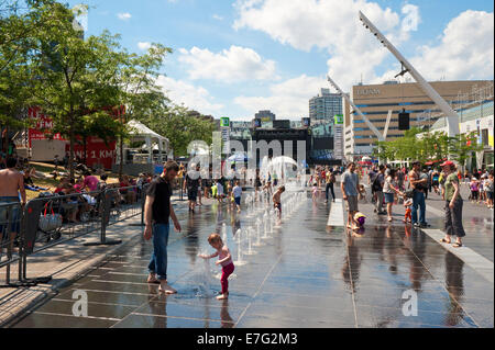 Les parents et les enfants appréciant les fontaines sur la Place des Festivals, Montréal, province de Québec, Canada. Banque D'Images