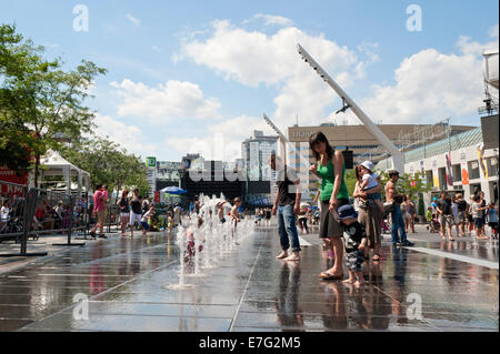 Les parents et les enfants appréciant les fontaines sur la Place des Festivals, Montréal, province de Québec, Canada. Banque D'Images