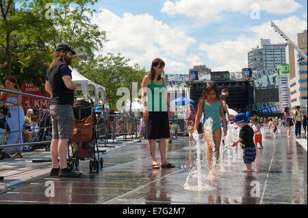 Les parents et les enfants appréciant les fontaines sur la Place des Festivals, Montréal, province de Québec, Canada. Banque D'Images