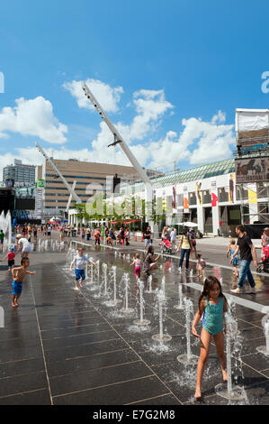 Les enfants appréciant les fontaines sur la Place des Festivals, Montréal, province de Québec, Canada. Banque D'Images