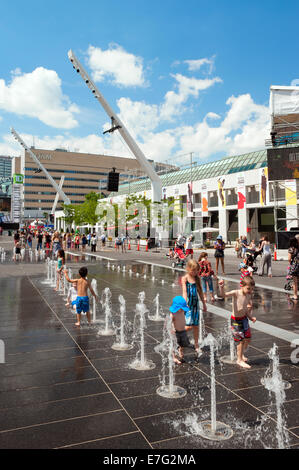 Les enfants appréciant les fontaines sur la Place des Festivals, Montréal, province de Québec, Canada. Banque D'Images