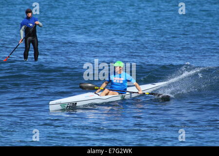 Un homme monte un vague sur son surf kayak en tant que stand up paddleboarder (SUP) ressemble à Cottesloe, Australie occidentale Banque D'Images