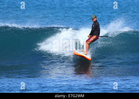 Un stand up paddleboarder (SUP) jouit d'un surfer sur l'océan Indien des vagues à Cottesloe Beach, Cottesloe du Sud, l'ouest de l'Australie. Banque D'Images