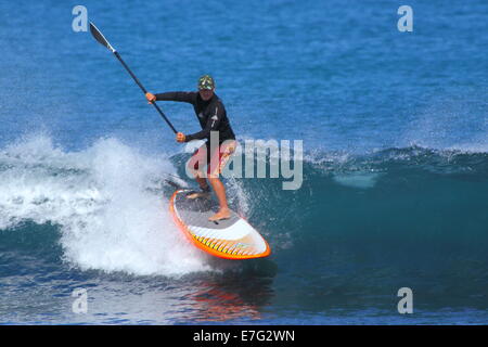 Un stand up paddleboarder (SUP) jouit d'un surfer sur l'océan Indien des vagues à Cottesloe Beach, Cottesloe du Sud, l'ouest de l'Australie. Banque D'Images