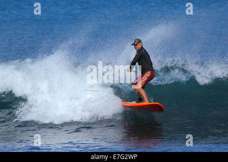 Un stand up paddleboarder (SUP) jouit d'un surfer sur l'océan Indien des vagues à Cottesloe Beach, Cottesloe du Sud, l'ouest de l'Australie. Banque D'Images