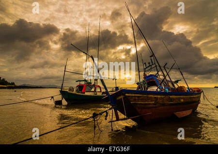 Bateau de pêche en mer et le lever du soleil les nuages avant strom en Thaïlande ton or Banque D'Images