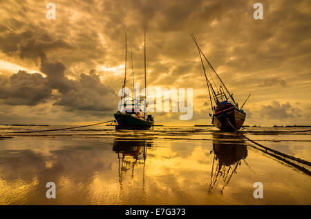 Bateau de pêche en mer et le lever du soleil les nuages avant strom en Thaïlande ton or Banque D'Images