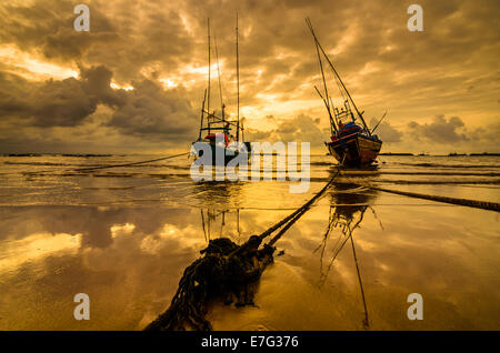 Bateau de pêche en mer et le lever du soleil les nuages avant strom en Thaïlande ton or Banque D'Images