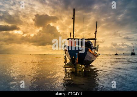 Bateau de pêche en mer et le lever du soleil les nuages avant strom en Thaïlande ton bleu Banque D'Images