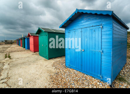 Une rangée de cabines colorées sous un ciel dramatique à St Leonards on Sea à Hastings, East Sussex Banque D'Images